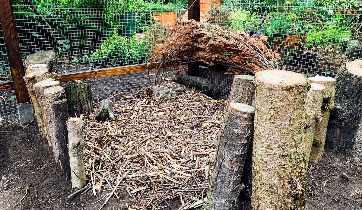 Hühnerauslauf mit Holz und natürlicher Begrenzung